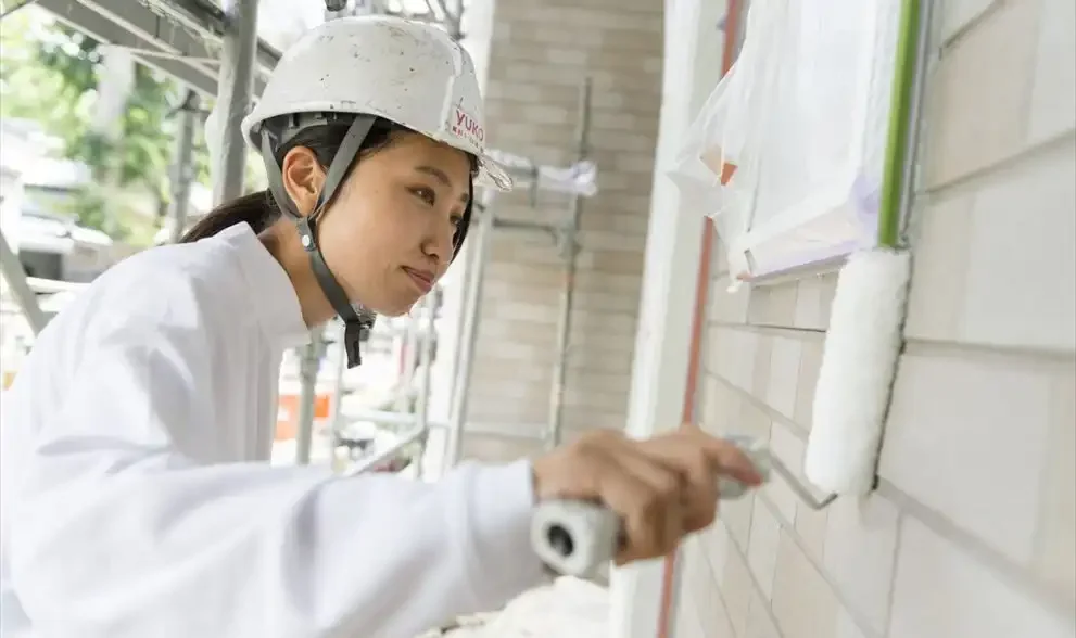 外壁塗装の中塗り作業を行う職人
